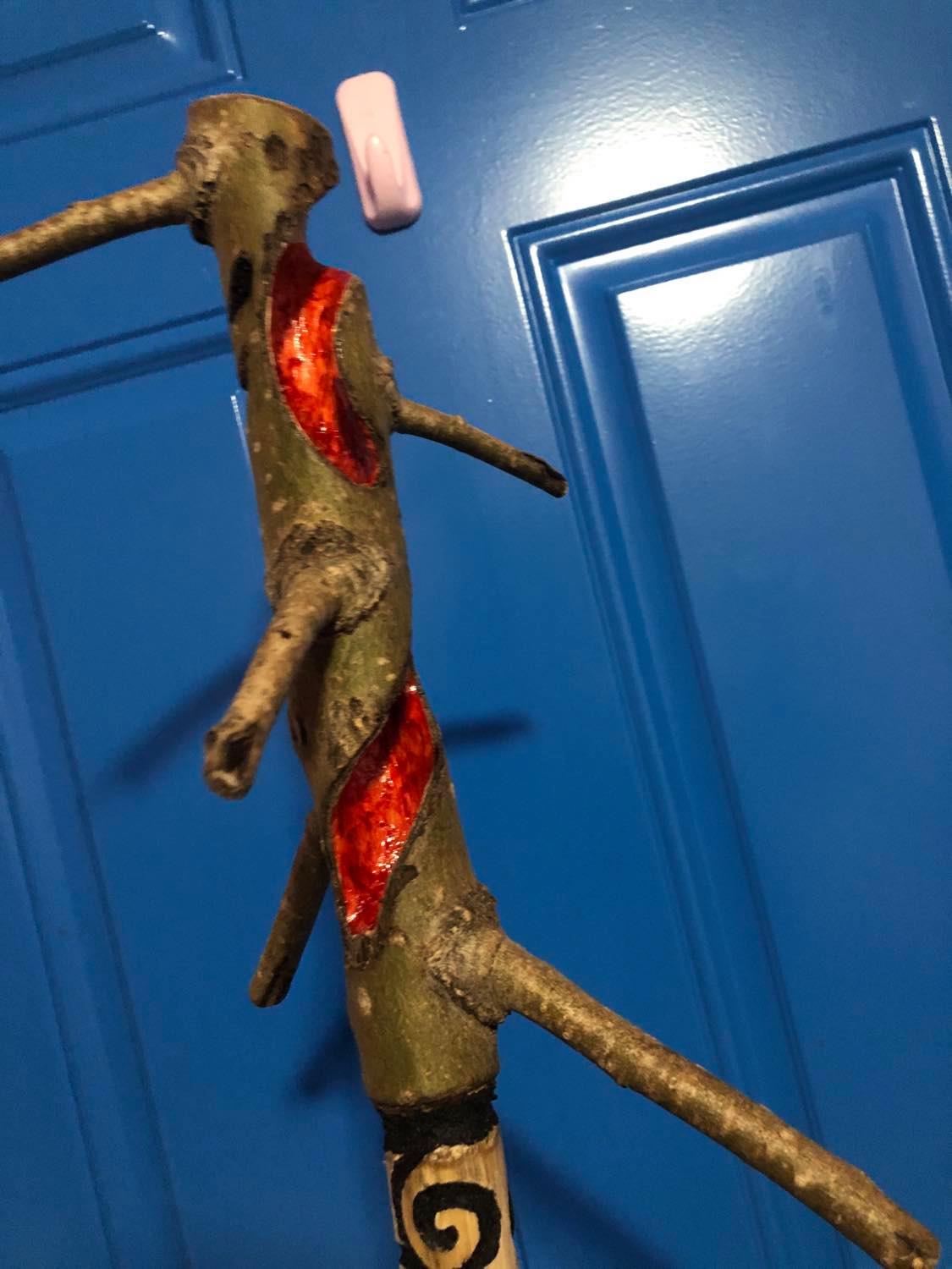 Showing the staff at an angle to show off the hidden fourth face that came up from scuffing of the bark, as well as the red mouth.