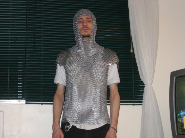 A pic of Kabutroid wearing the chainmaille shirt and coif together, standing in the livingroom.