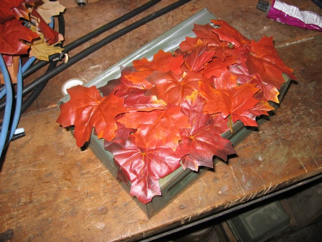The canister covered in leaves