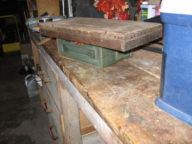 The leaves being flattened down with a wooden box to dry.