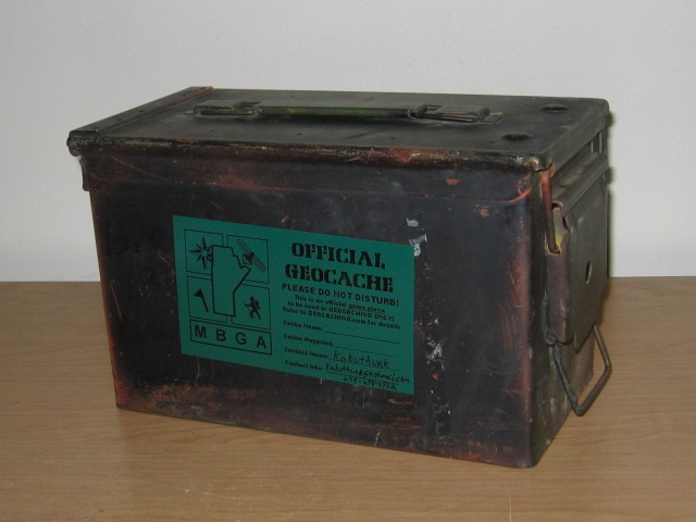 A metal canister with the official geocache sticker on the side.