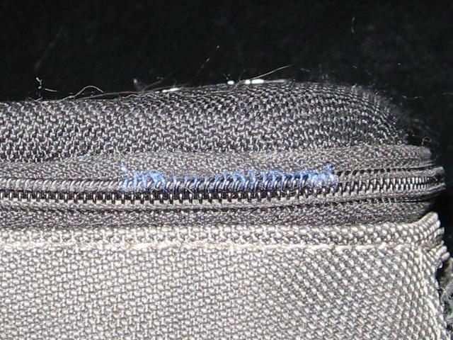 The zipper closed, with the thread holding the zipper in place.