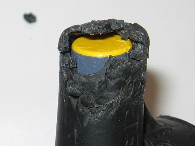 Showing the opening, bigger than before, with a chunk of rubber in the background.