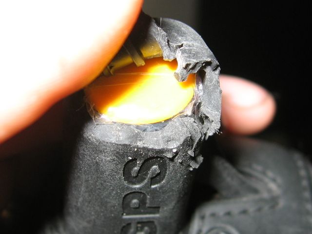 Peeling the torn rubber back to show the saran wrap over the yellow plastic.