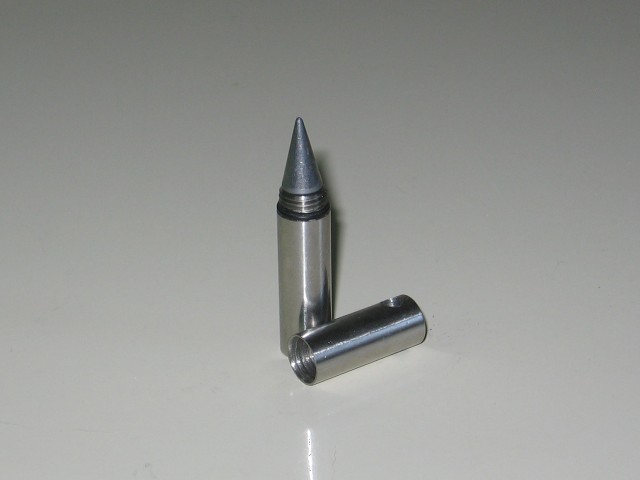 A small metal nib with a removable cap, on a plain countertop.