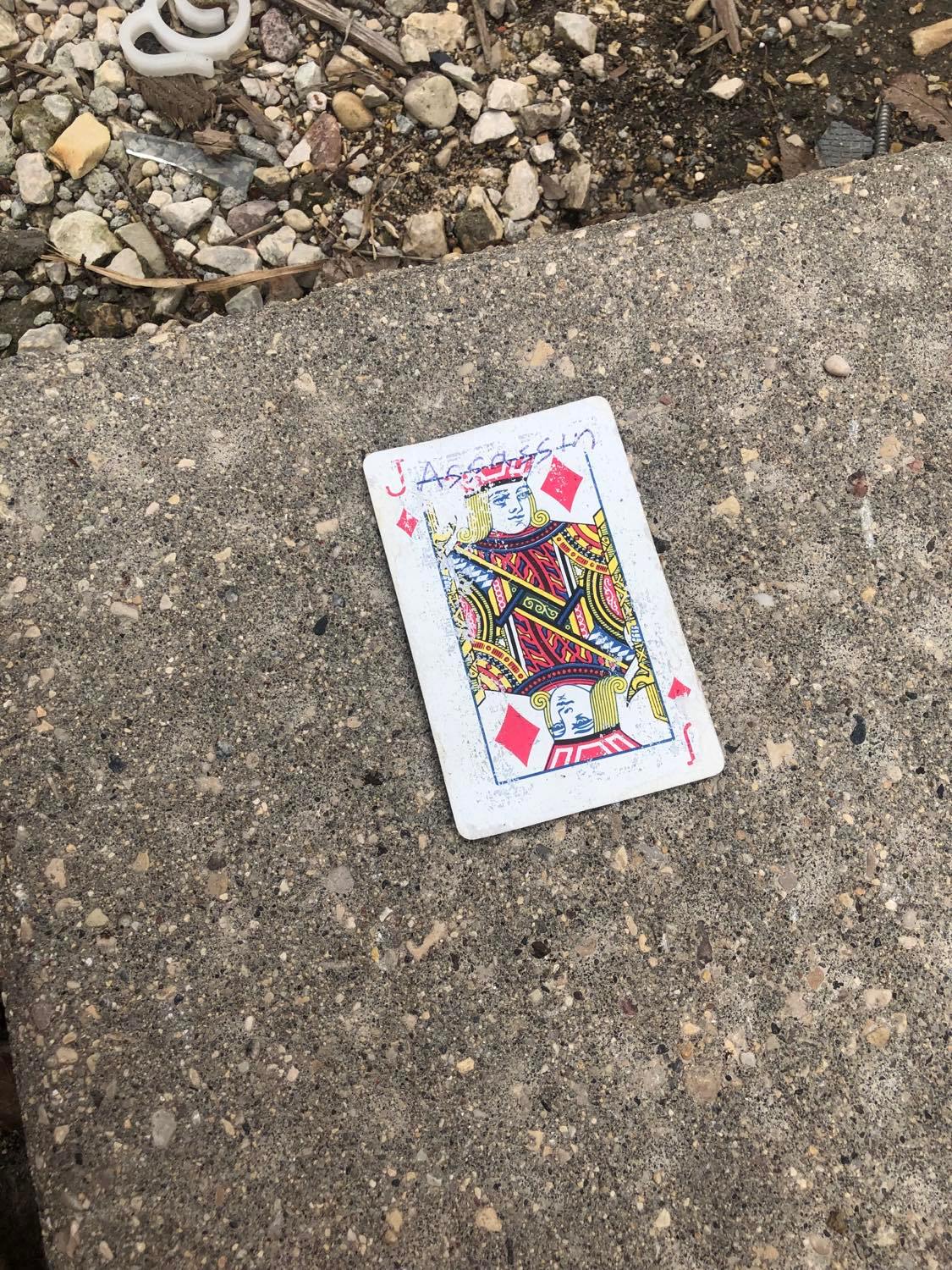 The jack of diamonds, laying on the ground before the creature.