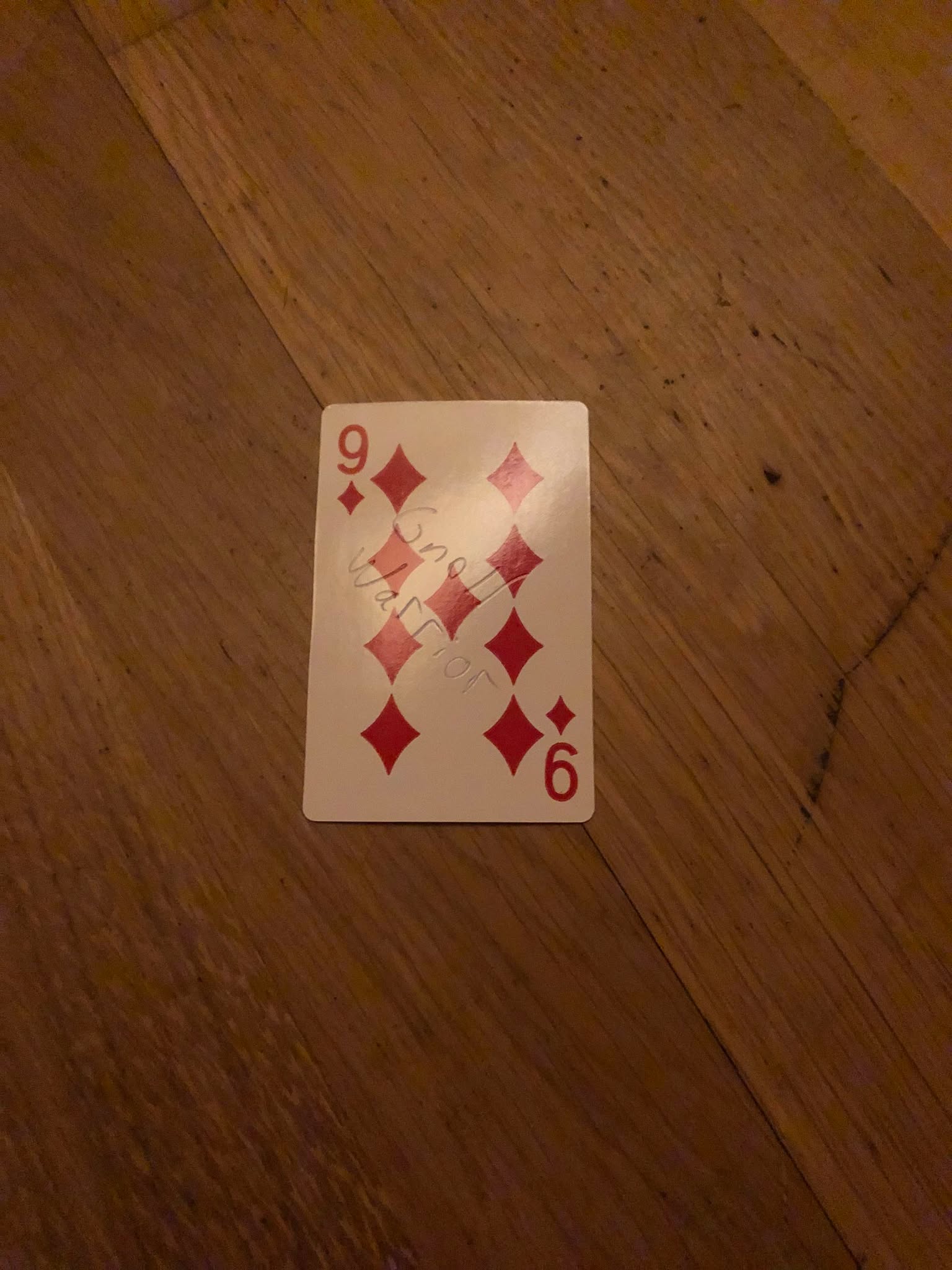 The nine of diamonds, thrown to the floor in front of the creature.