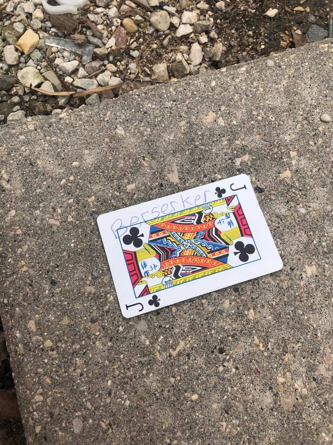 The jack of clubs, laying on the ground before the creature.