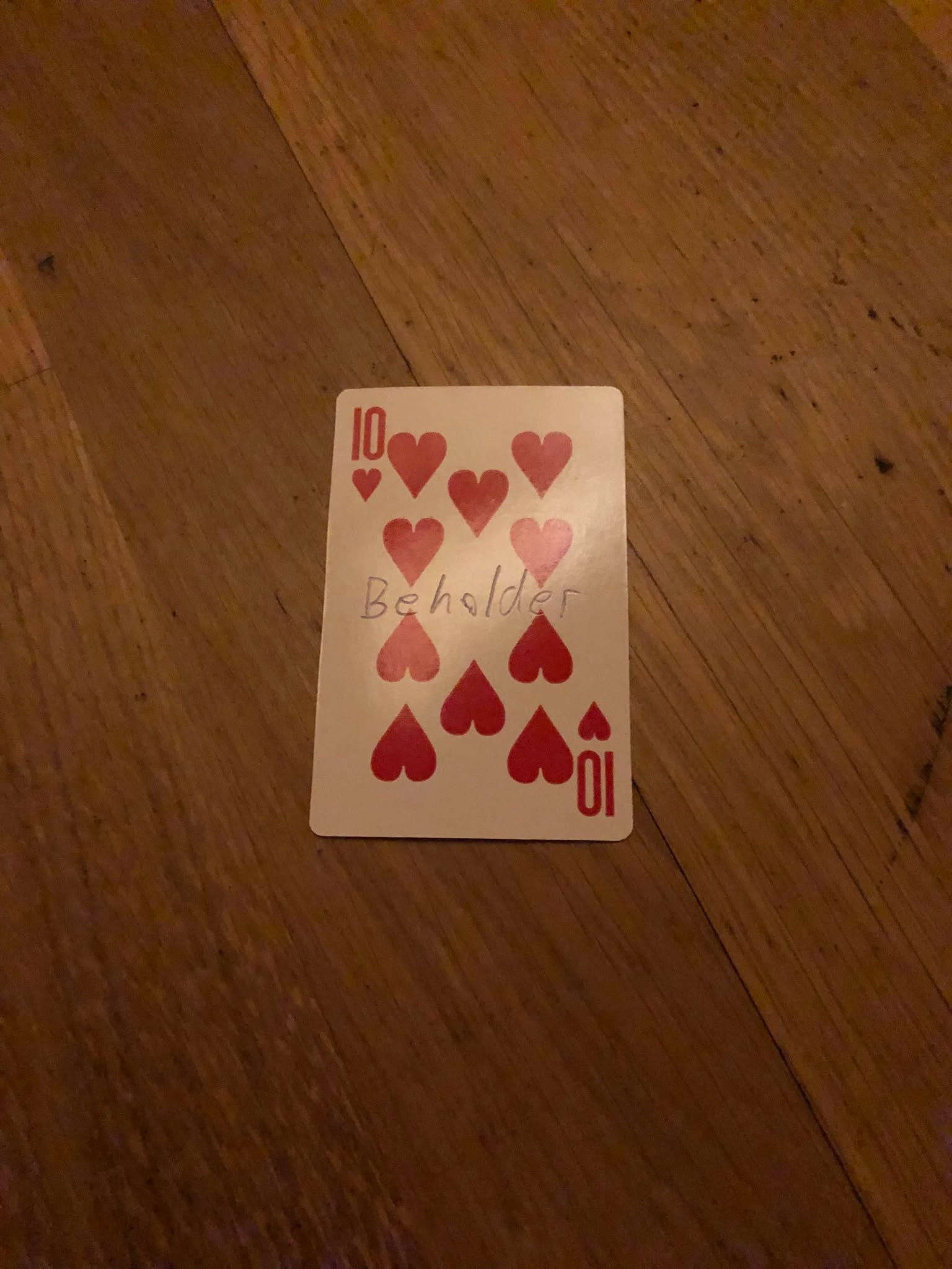 The ten of hearts, thrown to the floor in front of the creature.