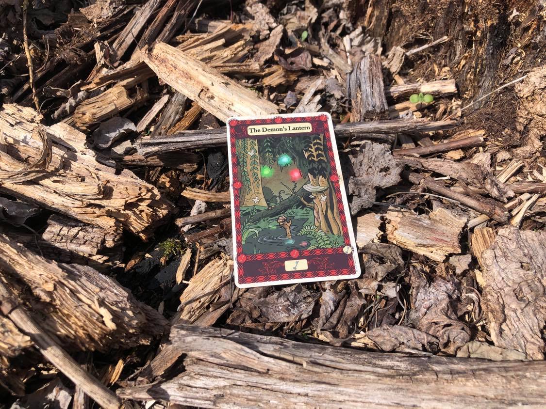 A body sunk in a swamp, the card laying on the forest debris.