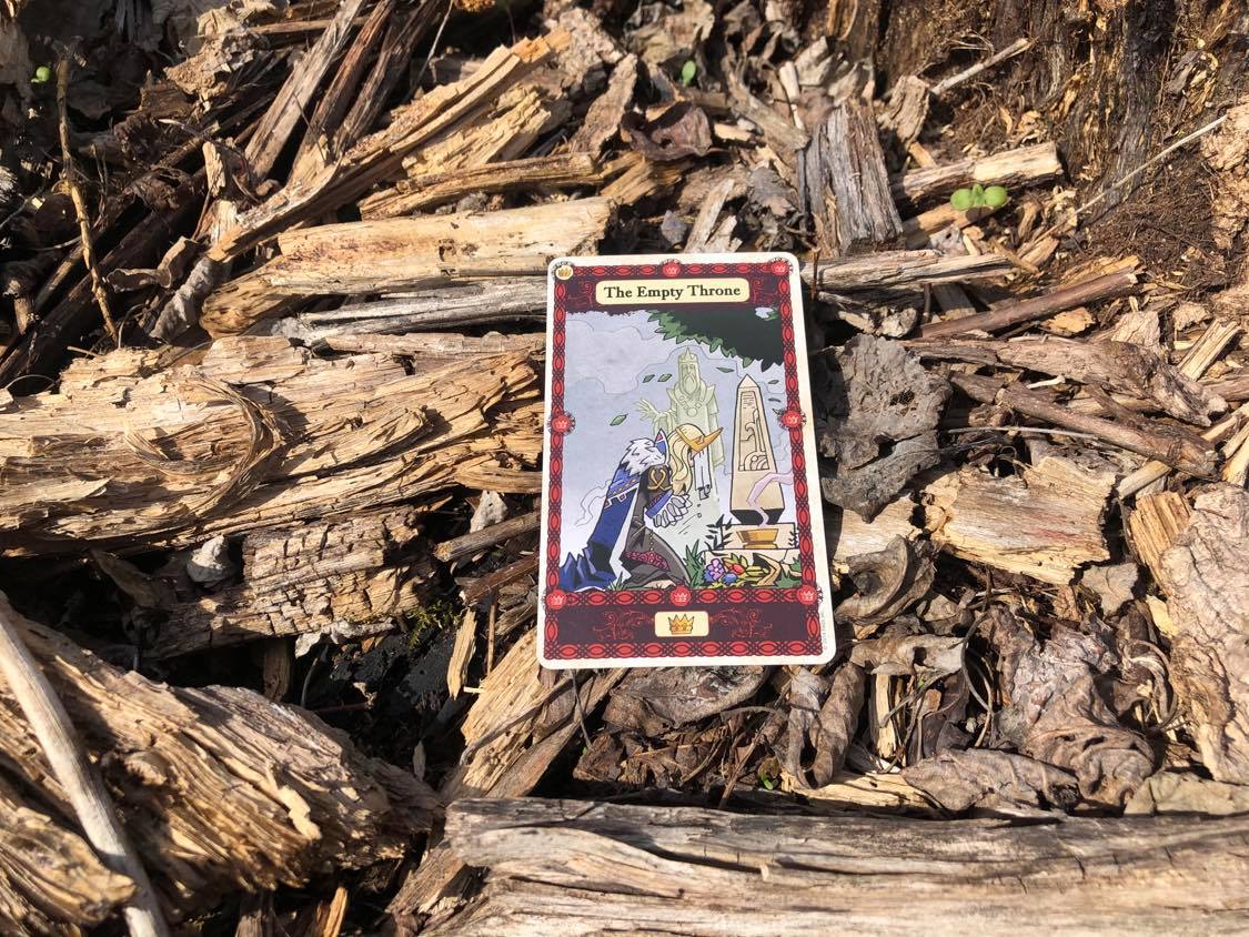 A person mourning the fallen, the card laying on the forest debris.