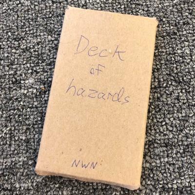 The Deck of hazards box, plain brown cardboard with handwritten lettering.