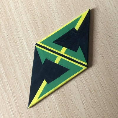 An diamond shaped emblem of a green and yellow angular S logo.