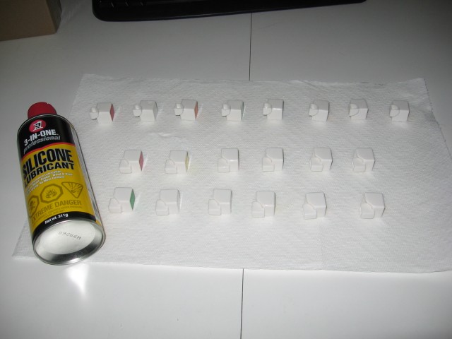 The pieces all arranged so that the inner faces are facing forwards, and a can of silicone lubricant spray is sitting beside them, on a paper towel.