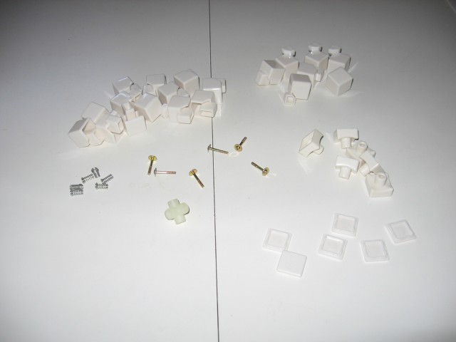 The pieces spread out on the table, arranged into sections, corners, middles, and screws and springs.