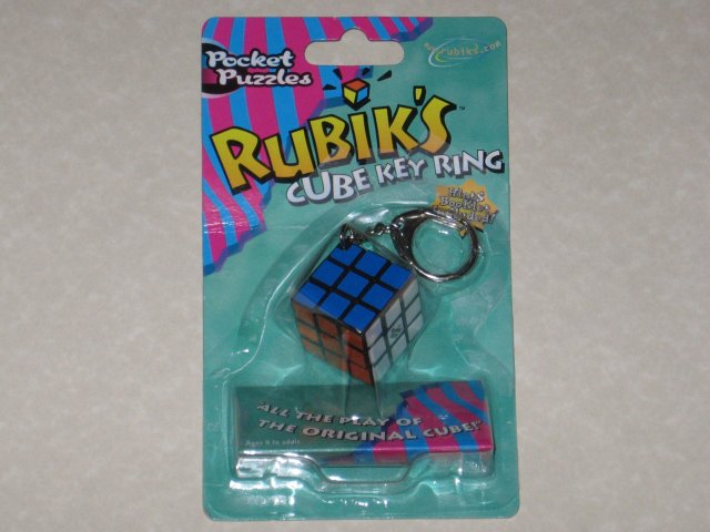 A sealed package for a new Rubik's cube keychain, in bright green and colourful packaging.