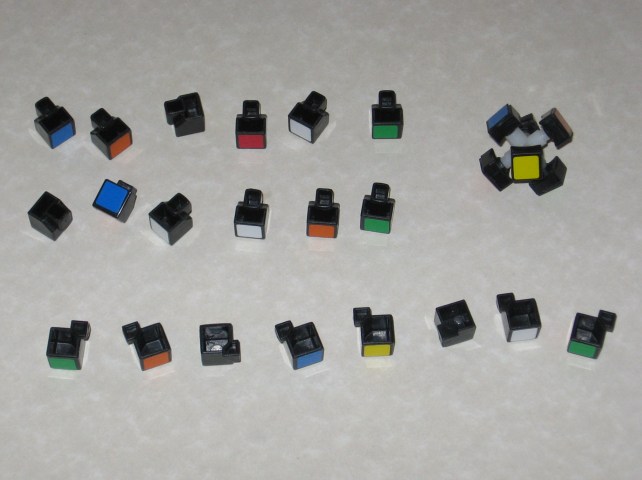 All of the cubies disassembled and neatly arranged, showing all of the empty sides of the pieces.