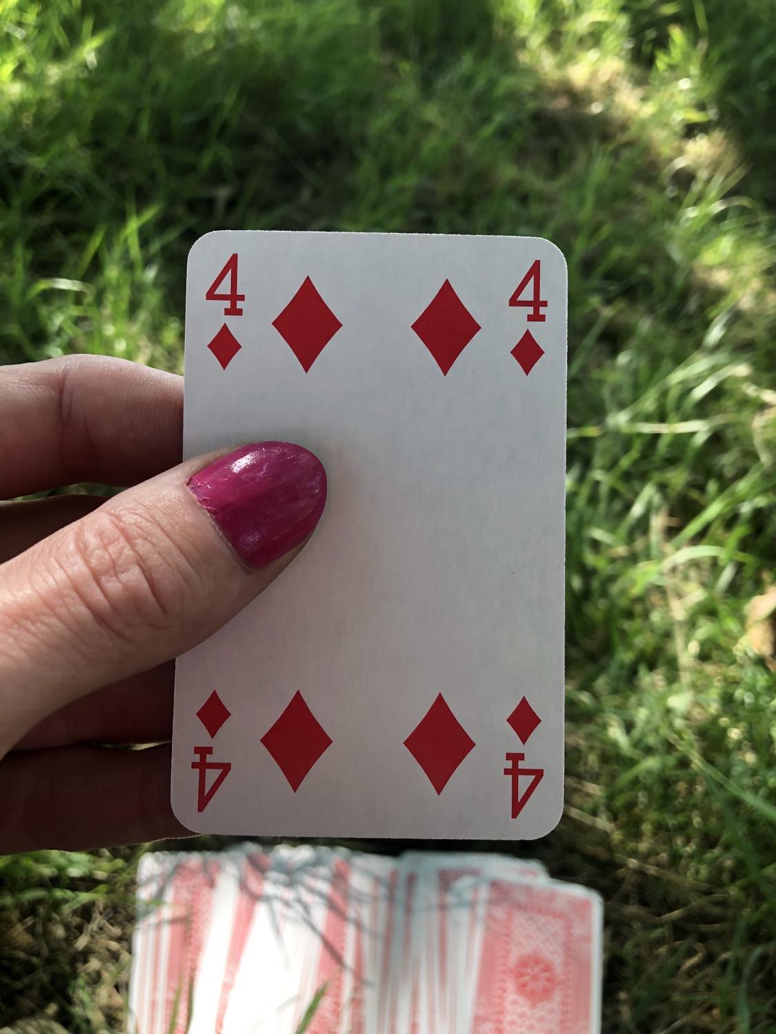 The four of diamonds, held up from the drawn out cards.