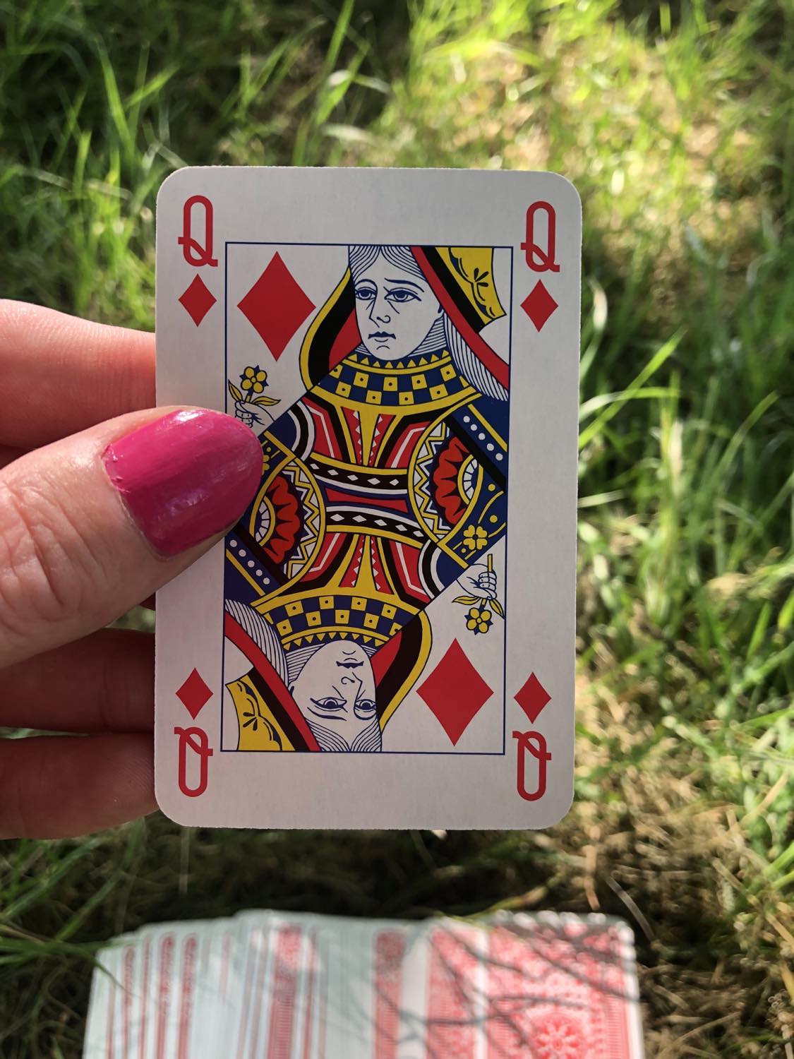 The queen of diamonds, held up from the drawn out cards.