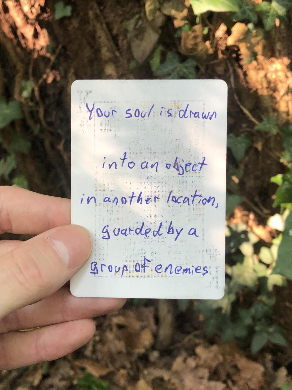 The king of clubs, held above the detritus on the ground. Your soul is drawn into an object in another location, guarded by a group of enemies.