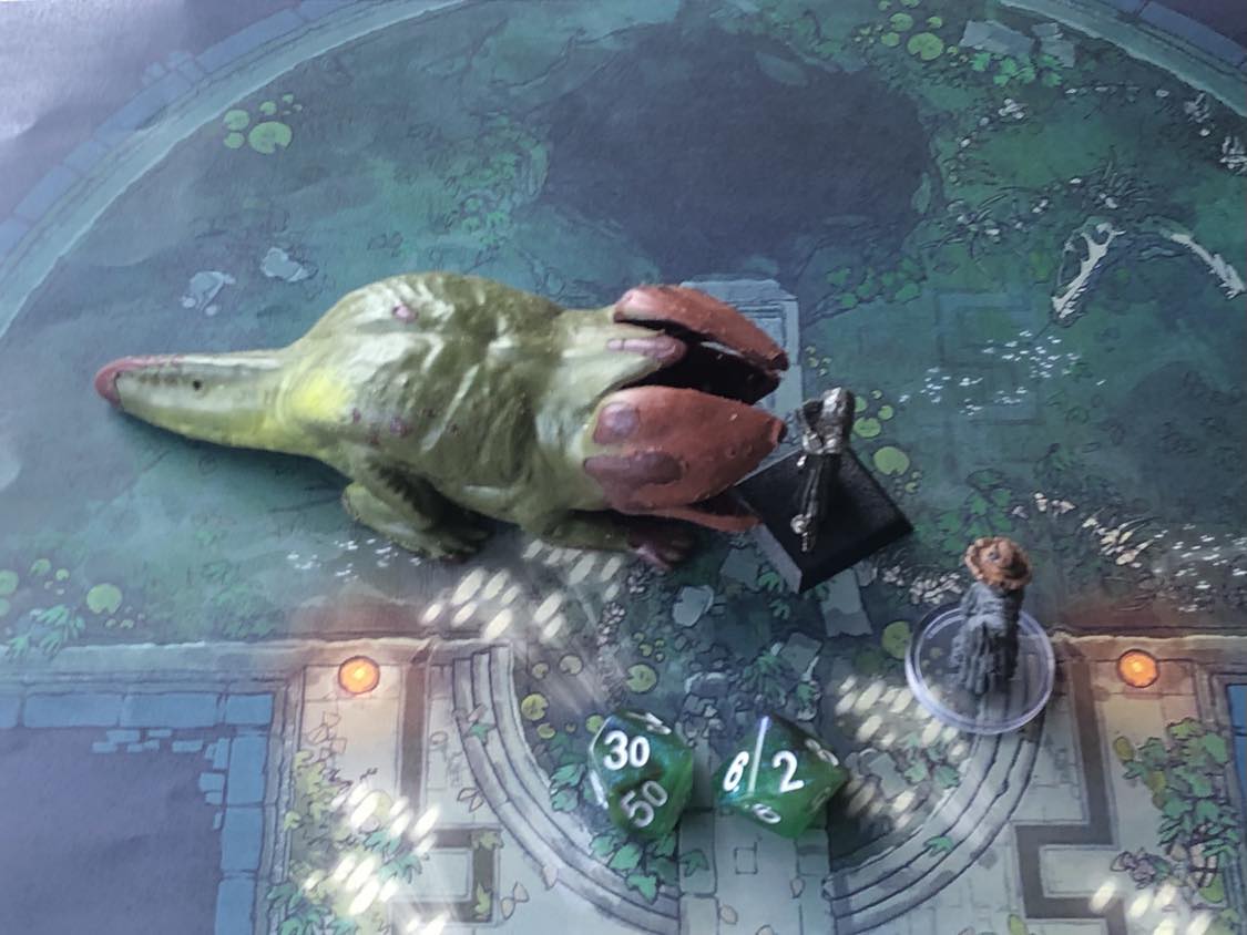 The battle map from above, with the monk fully attacking the creature, and the sorcerer rolling a pair of d10 dice to determine the wild magic surge.