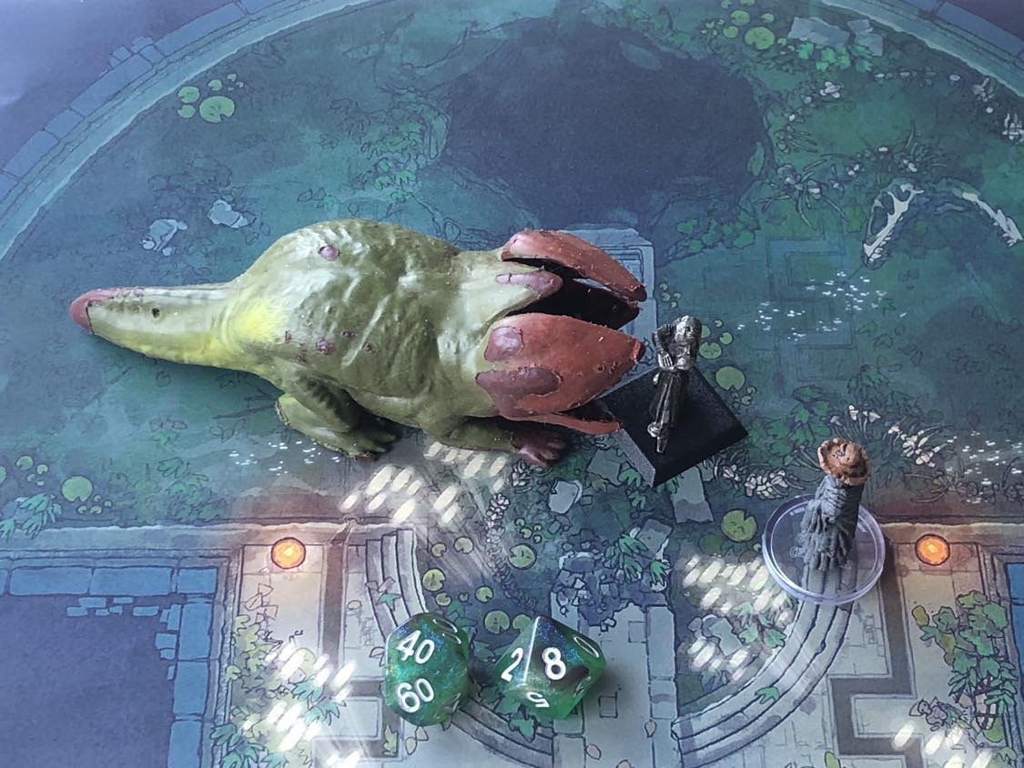 The battle map from above, with the monk fully attacking the creature, and the sorcerer rolling a pair of d10 dice to determine the wild magic surge.